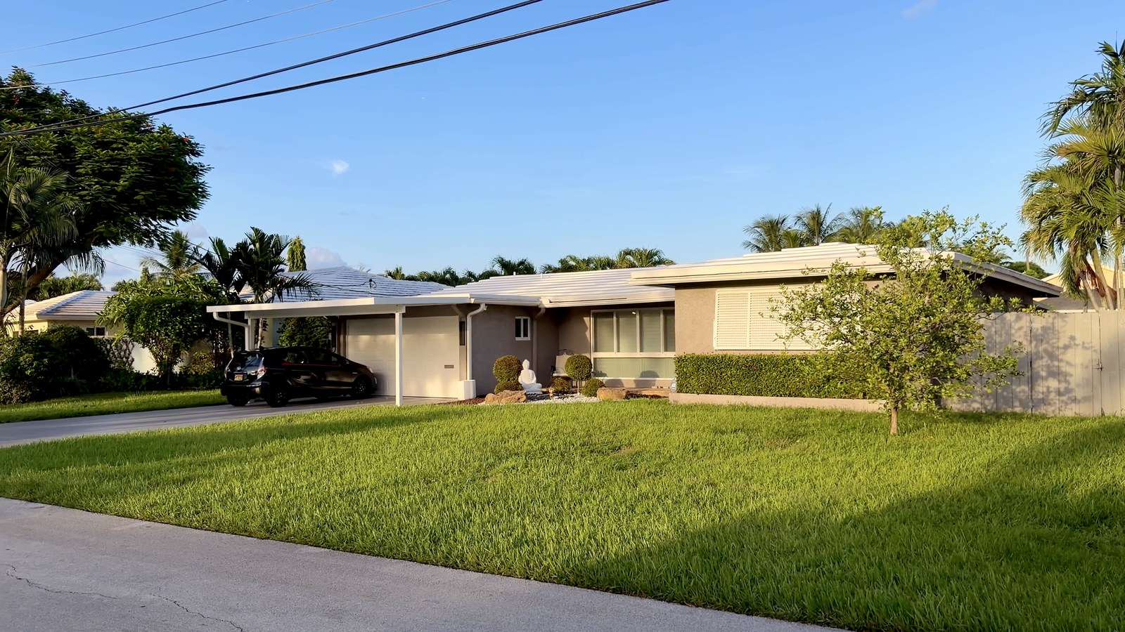 Casa residencial con césped amplio y palmeras