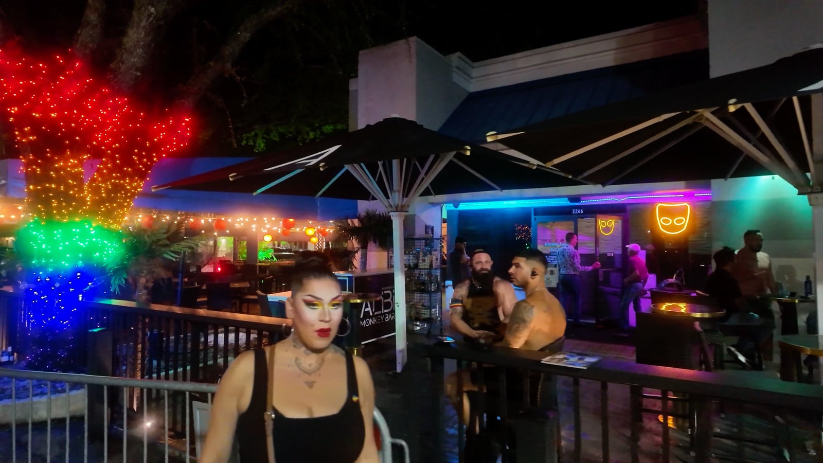 Personas bajo luces de colores en una terraza de Wilton Manors de noche