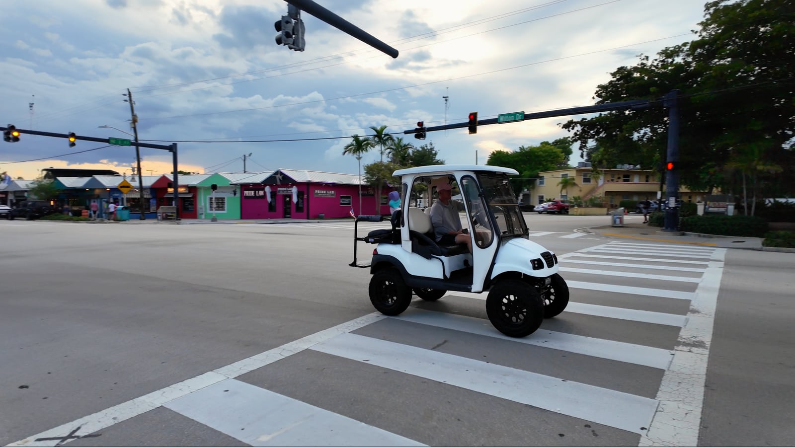 Un vehículo pequeño cruza una intersección tranquila de Wilton Manors