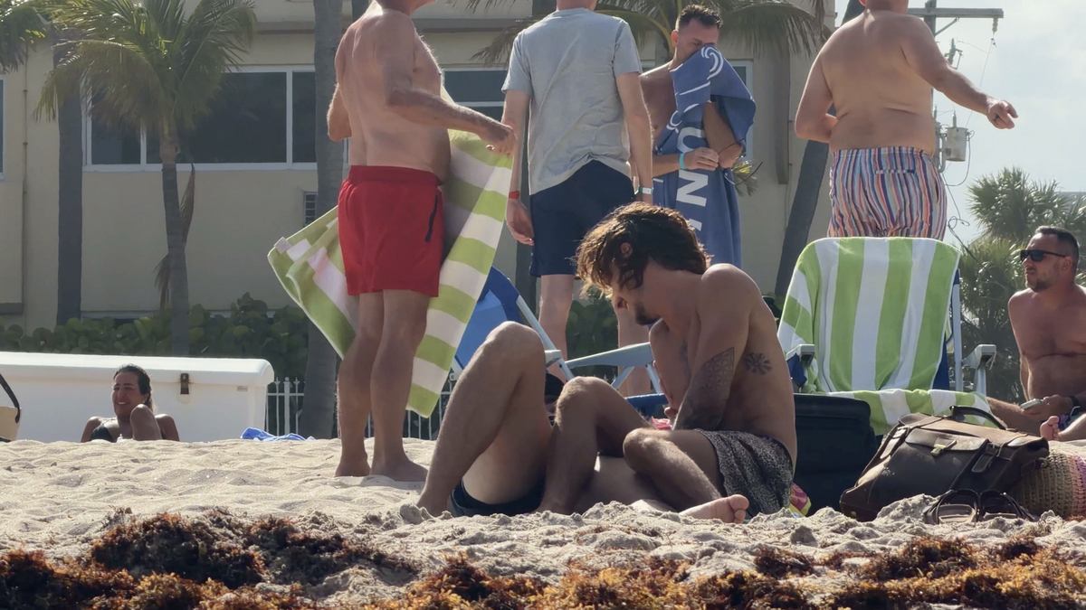 Grupo LGBTQ+ con una bandera arcoíris en Sebastian Beach