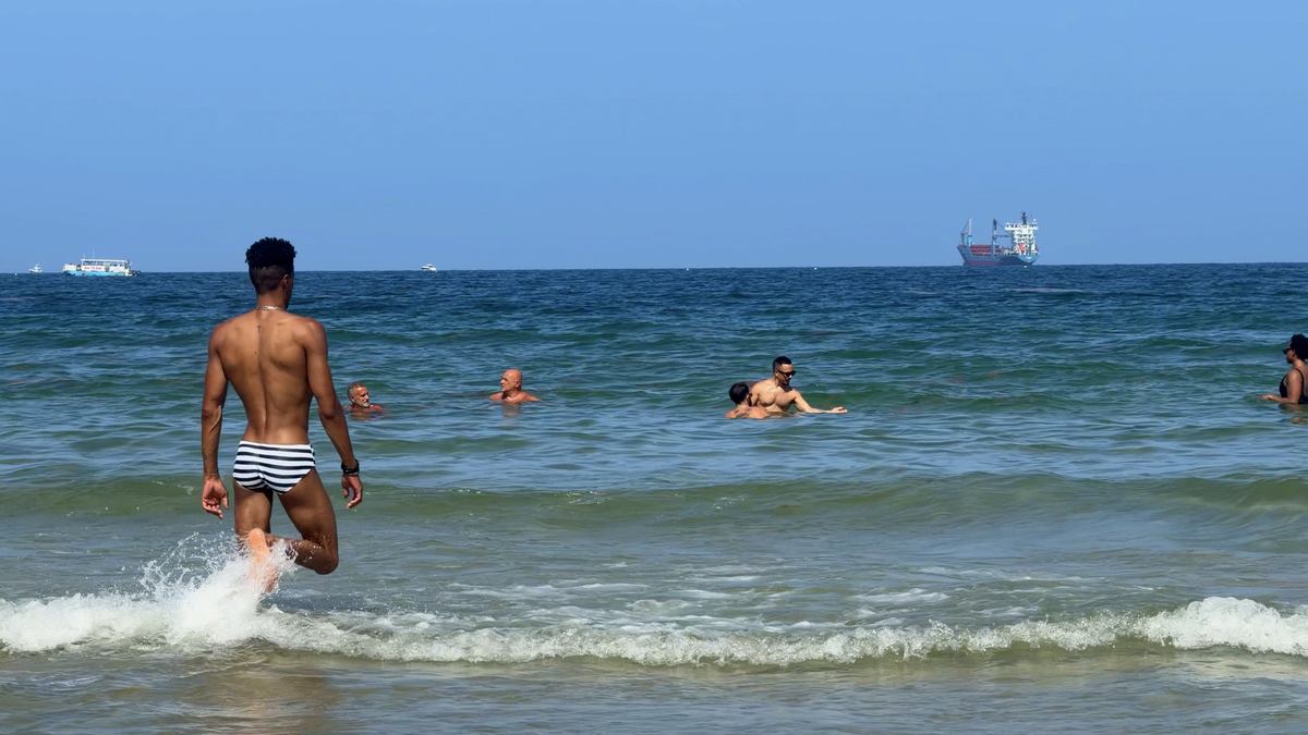 Visitante caminando hacia el mar en Sebastian Beach