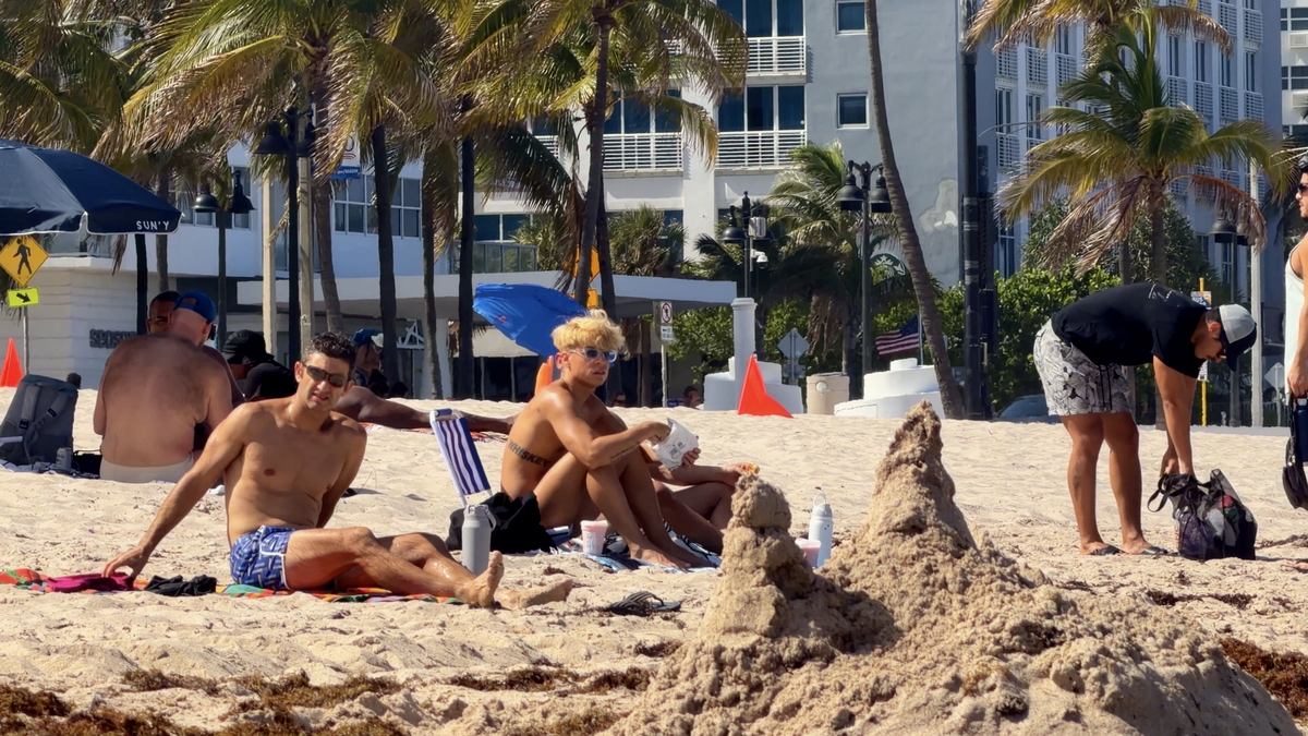 Personas junto a un castillo de arena en Sebastian Beach