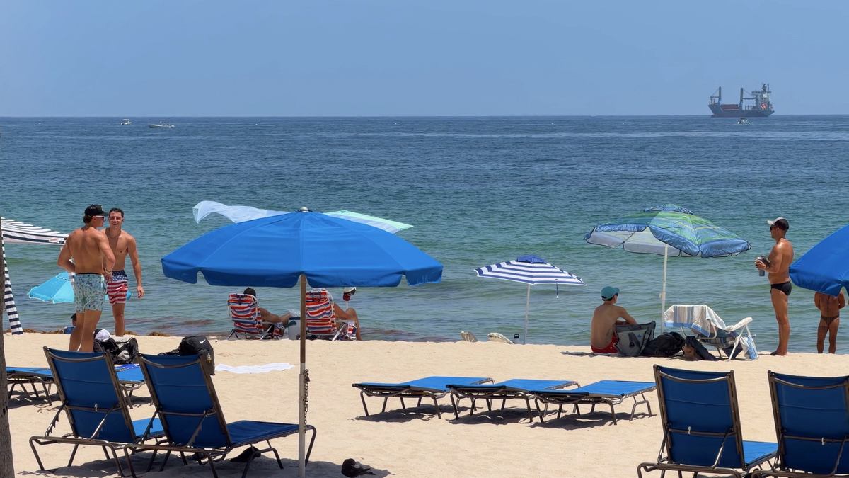Sillas de playa con un crucero visible en el horizonte